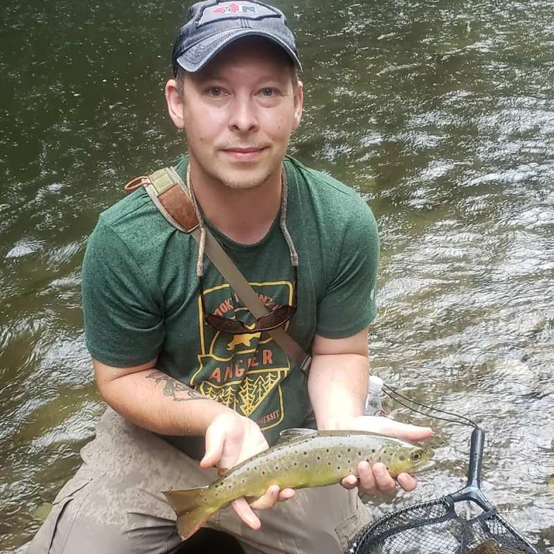 a person holding a fish on a boat in the water