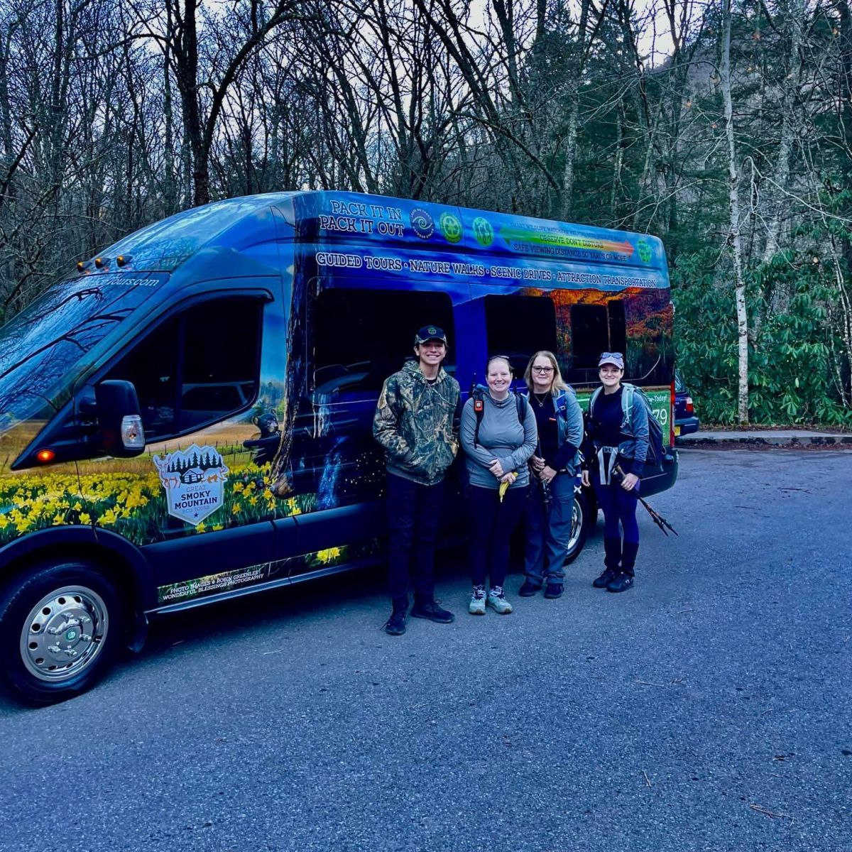 a group of people standing in front of a blue car
