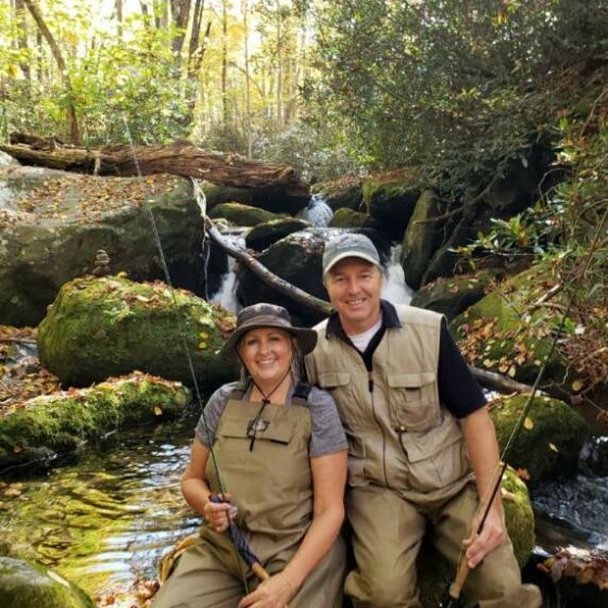 a group of people standing next to a river