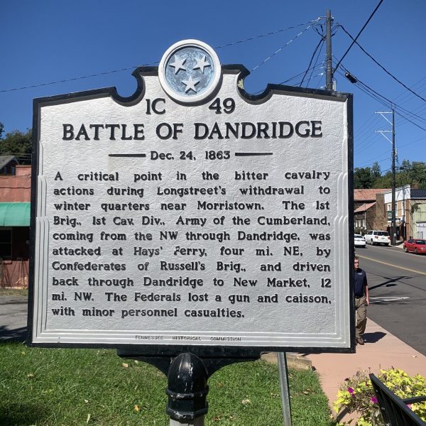 a pole that has a sign on the side of the street