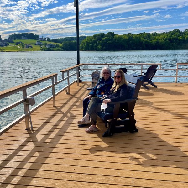 a group of people sitting on a bench next to a body of water