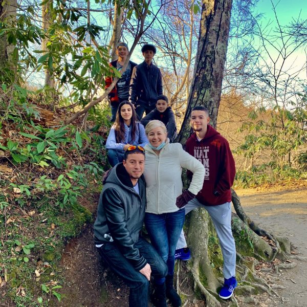 a group of people standing next to a tree