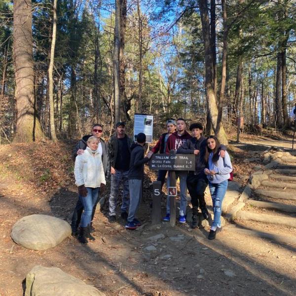 a group of people walking down a dirt road