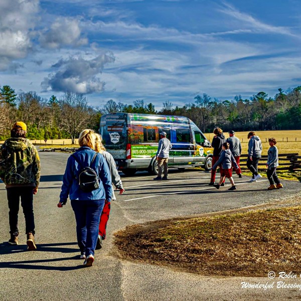 a group of people standing on top of a dirt road