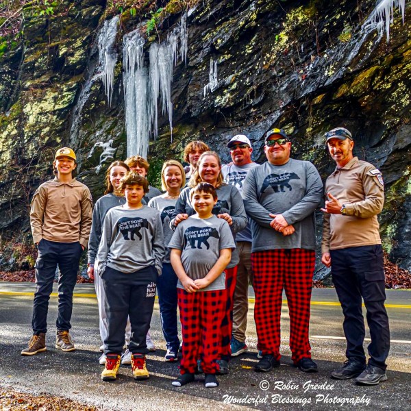 a group of people posing for the camera on a road