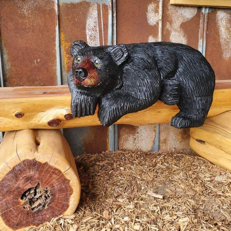 a bear sitting on top of a wooden chair