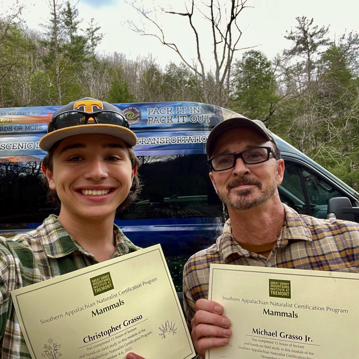 a person holding a sign posing for the camera